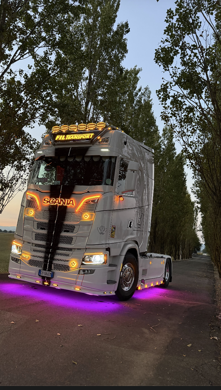 Scania bianco FIL TRANSPORT con le luci accese al calar della sera